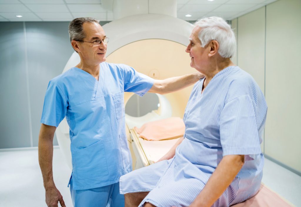 Technologist comforting patient before MRI exam