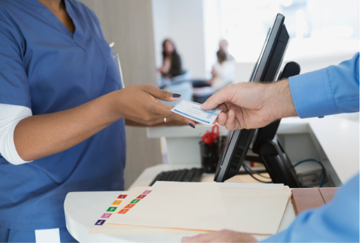 Patient giving insurance card to receptionist